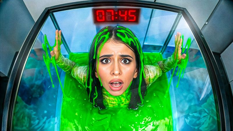 Woman inside a glass tank filling with green slime, red countdown clock above